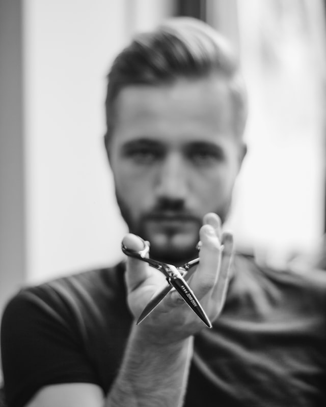 Portrait d'un barbier tenant ses ciseaux