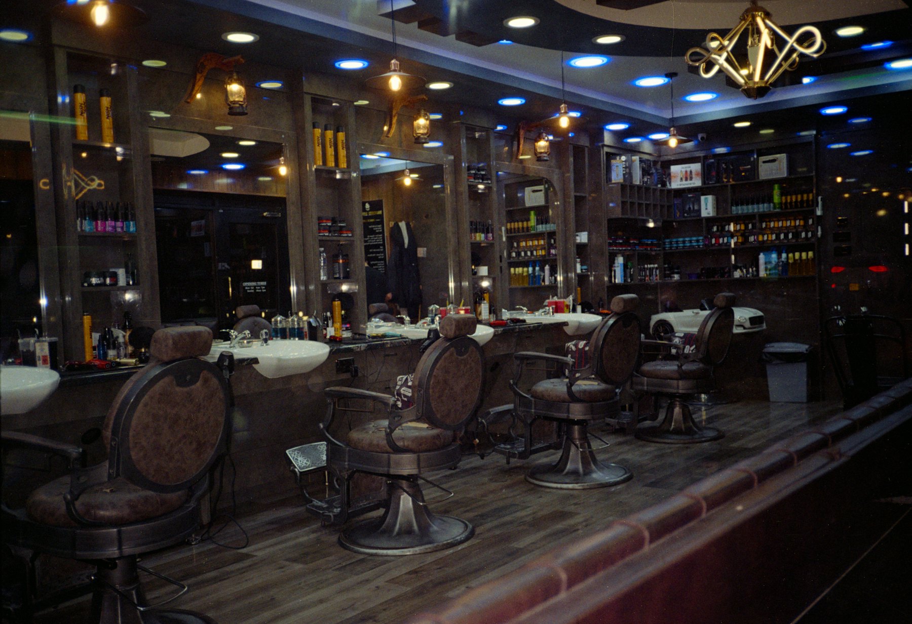 Salon de barbier, fauteuils en cuir alignés devant les miroirs